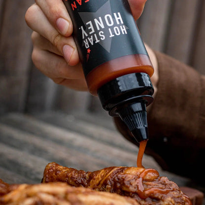 Asian-inspired Korean Buffalo Honey Sauce by Hot Star Honey drizzled on crispy chicken wings, showcasing a glossy, flavorful glaze.