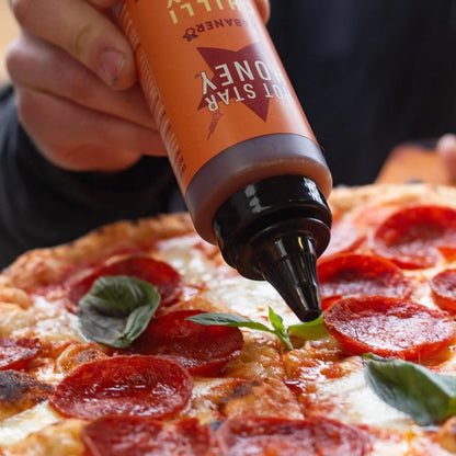 Spicy habanero hot chili honey drizzle on pizza, showcasing vibrant orange honey with sliced habanero peppers.