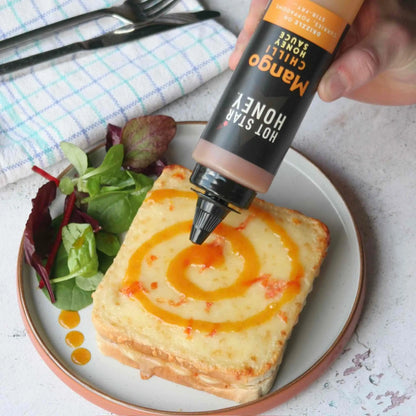 Asian-inspired Mango Chilli Honey Sauce by Hot Star Honey drizzled on toast with fresh mango slices.