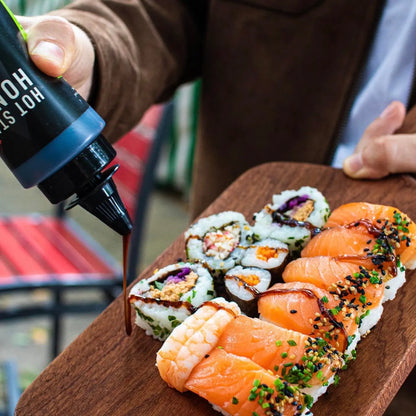 Asian inspired Hot Star Honey sweet soy sauce drizzled on sushi with chili and black garlic flavors.