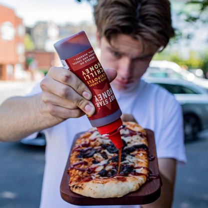 Hot Star Honey Chipotle Chilli Honey drizzled on a pizza, showcasing its spicy, sweet flavor and rich amber color.