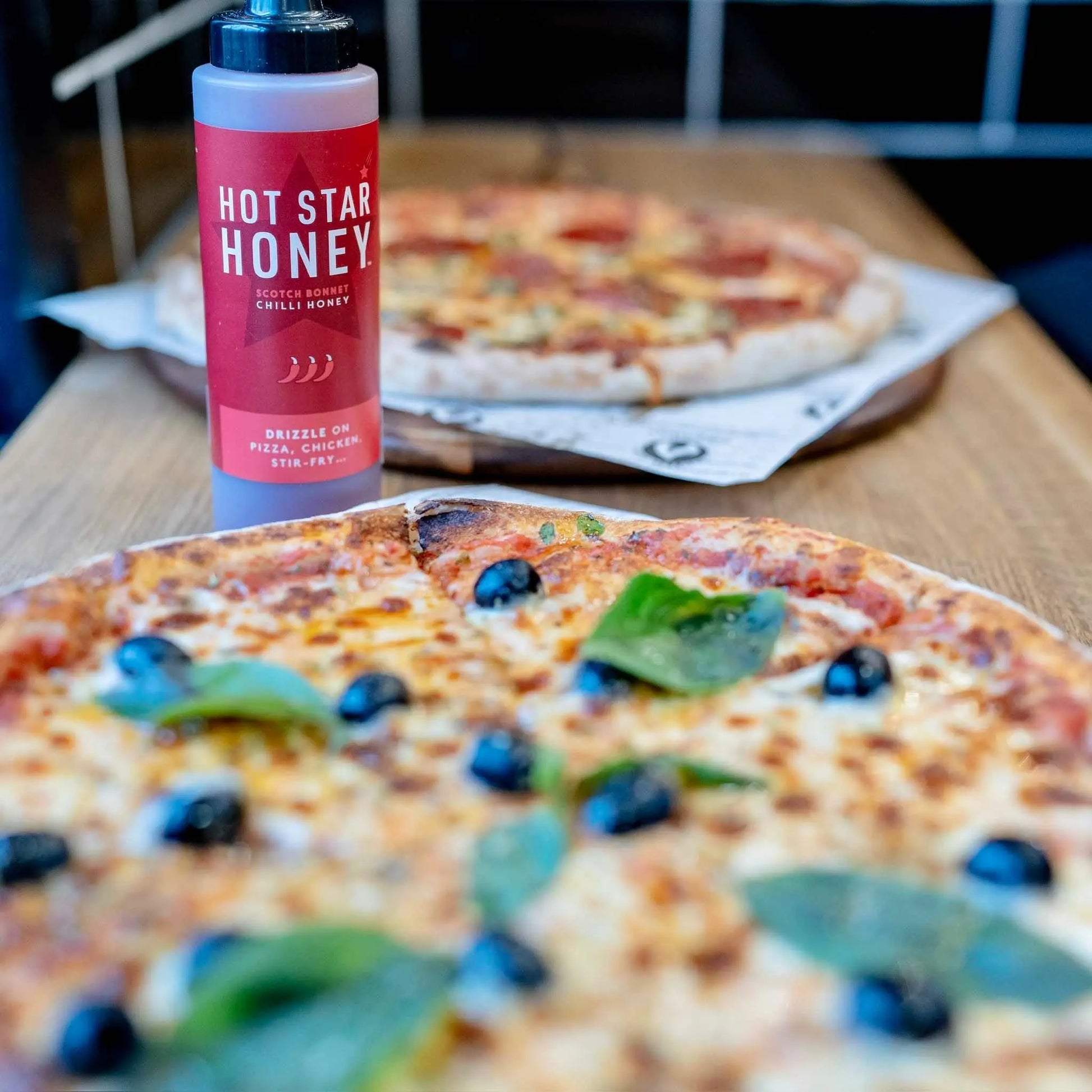 Spicy Scotch Bonnet chilli honey drizzled on a pizza, showcasing the Hot Star Honey Chilli Honey product with vibrant chilli and honey