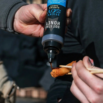 Asian-inspired Hot Star Honey sticky soy dipping sauce drizzled on a spring roll for dipping and flavor.
