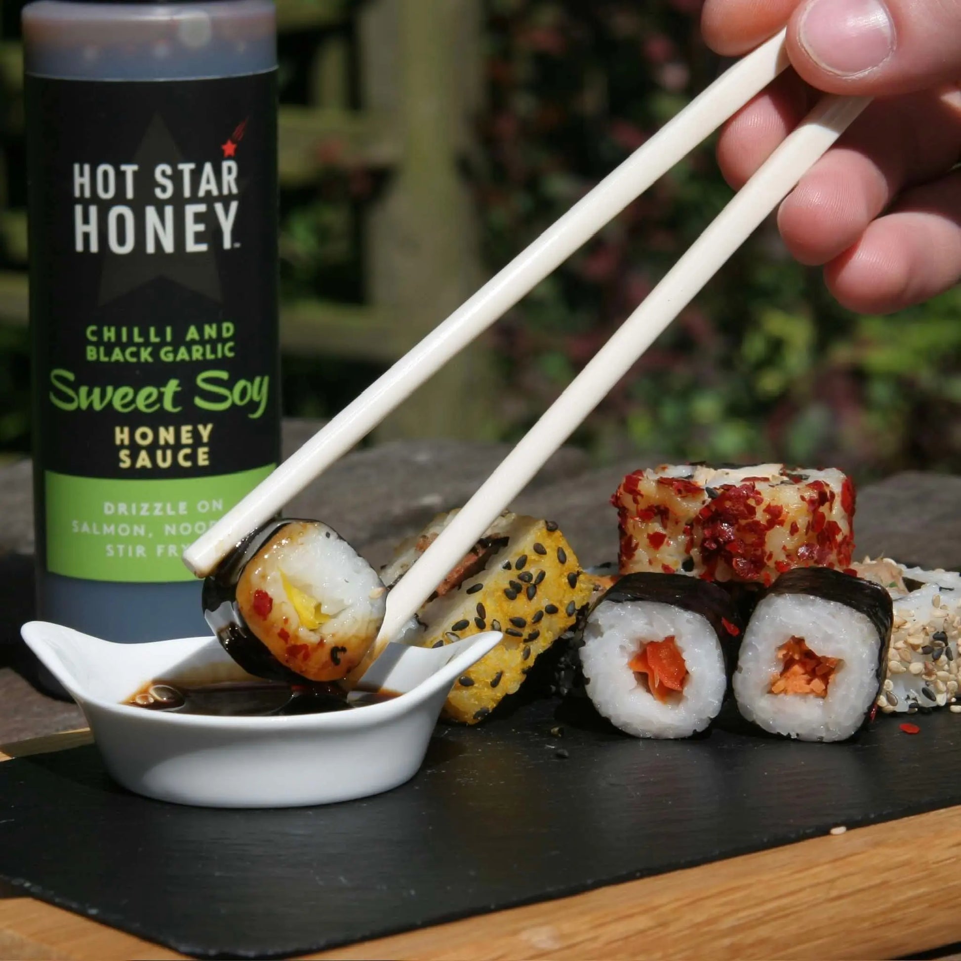 Asian-inspired hot star honey sweet soy sauce drizzled on sushi with chili and black garlic flavors