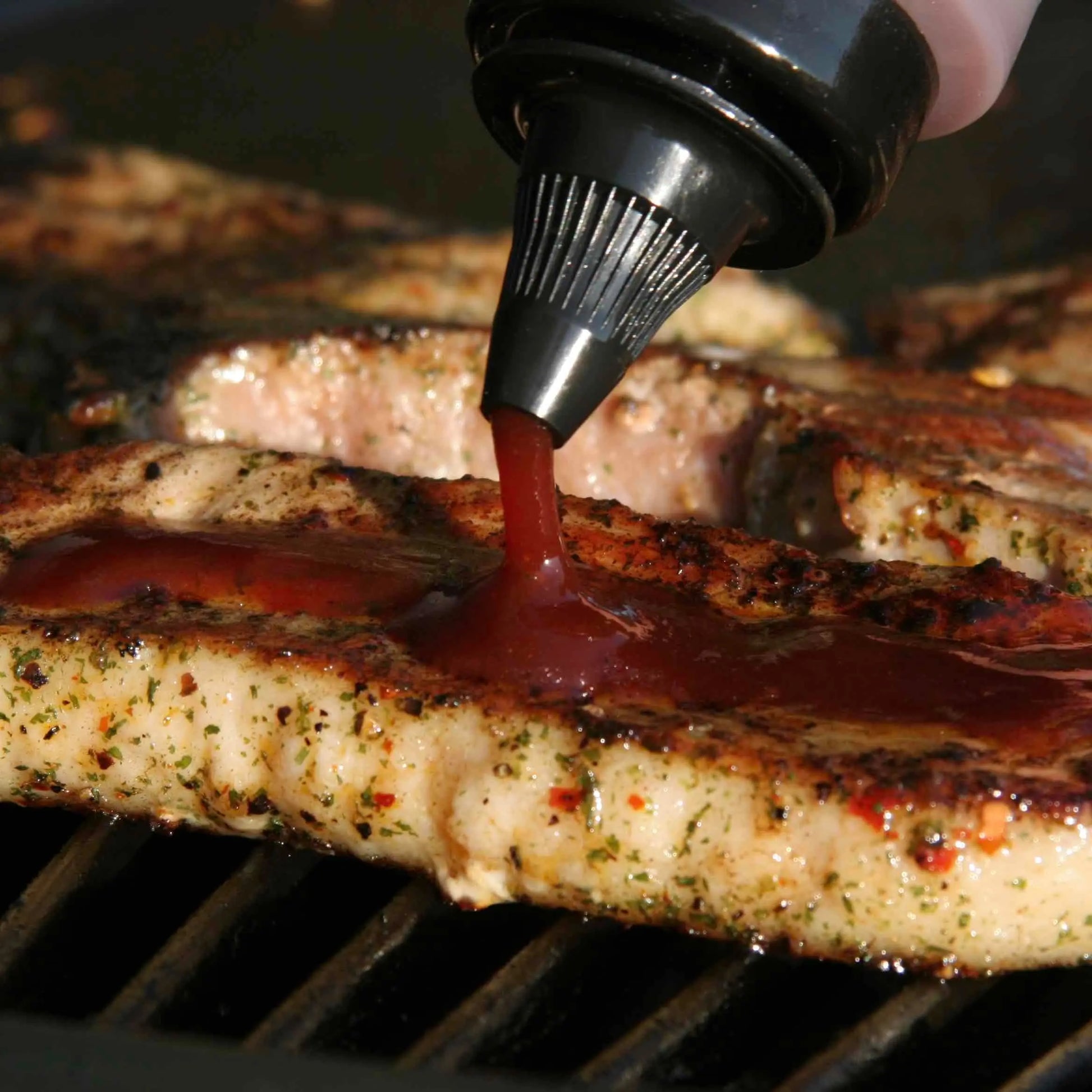 Hot Star Honey Caribbean BBQ Honey Sauce drizzled on grilled meat, showcasing its rich, sweet, and smoky flavor.