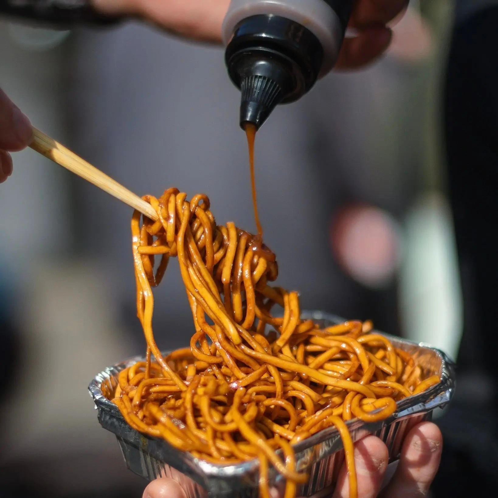 Asian-inspired Sticky Soy Dipping Sauce drizzled over noodles, showcasing a glossy, flavorful soy glaze on a plate.