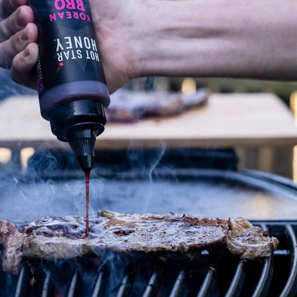 Hot Star Honey Korean BBQ sauce drizzled on grilled steak, showcasing a glossy, flavorful glaze on a barbecue dish.