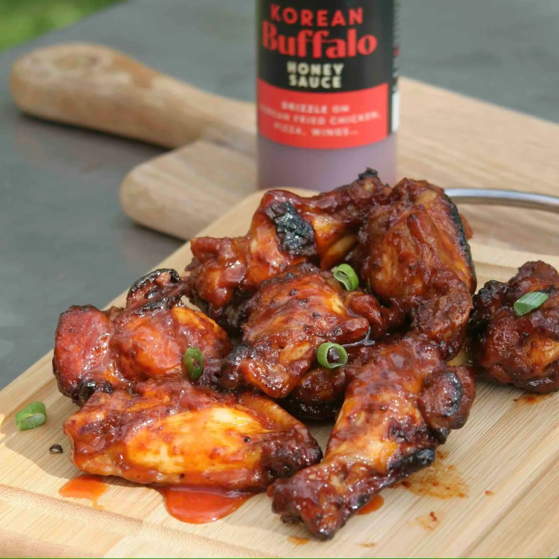 Asian-inspired Korean Buffalo Honey Sauce by Hot Star Honey, shown drizzled over crispy chicken wings.