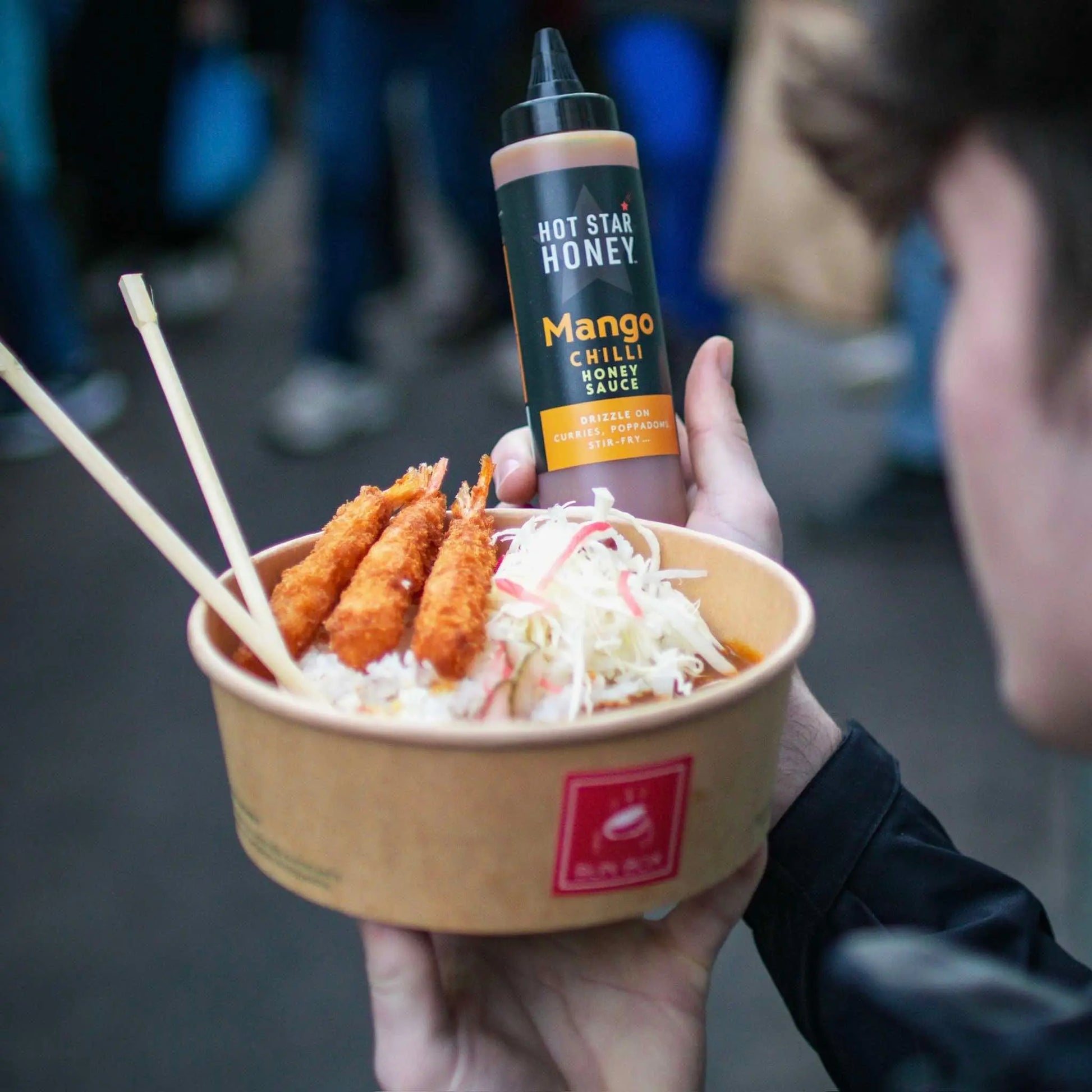Asian-inspired Mango Chilli Honey Sauce by Hot Star Honey with fresh mango slices and vibrant chili peppers on a dish