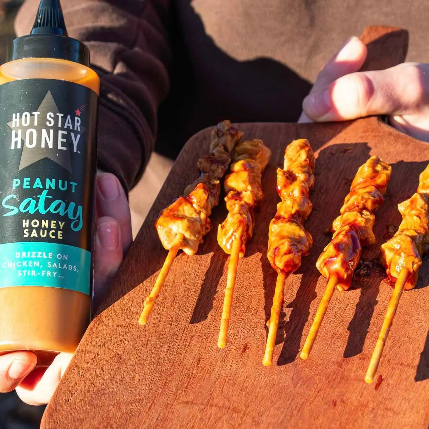 Asian-inspired Hot Star Honey Peanut Satay Sauce drizzled over grilled chicken, showcasing its creamy texture and rich flavor.