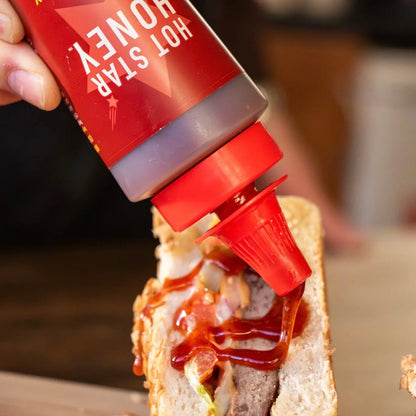 Hot Star Honey Chipotle Chilli Honey drizzled on a burger, showcasing its spicy, sweet flavor and thick honey texture.