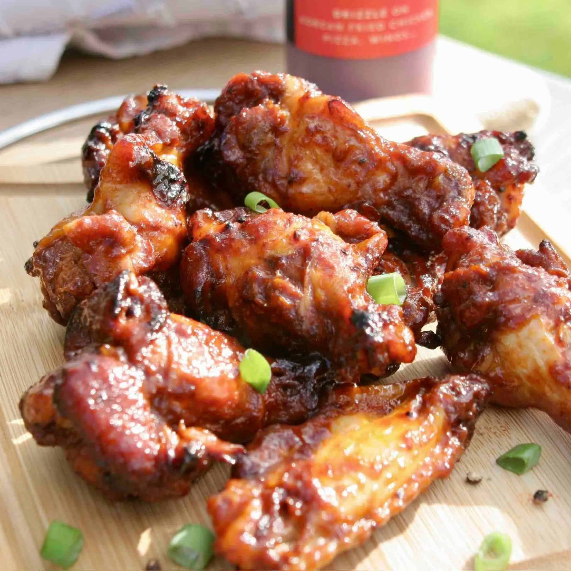 Asian-inspired Korean Buffalo Honey Sauce by Hot Star Honey drizzled over crispy chicken wings in a close-up shot.