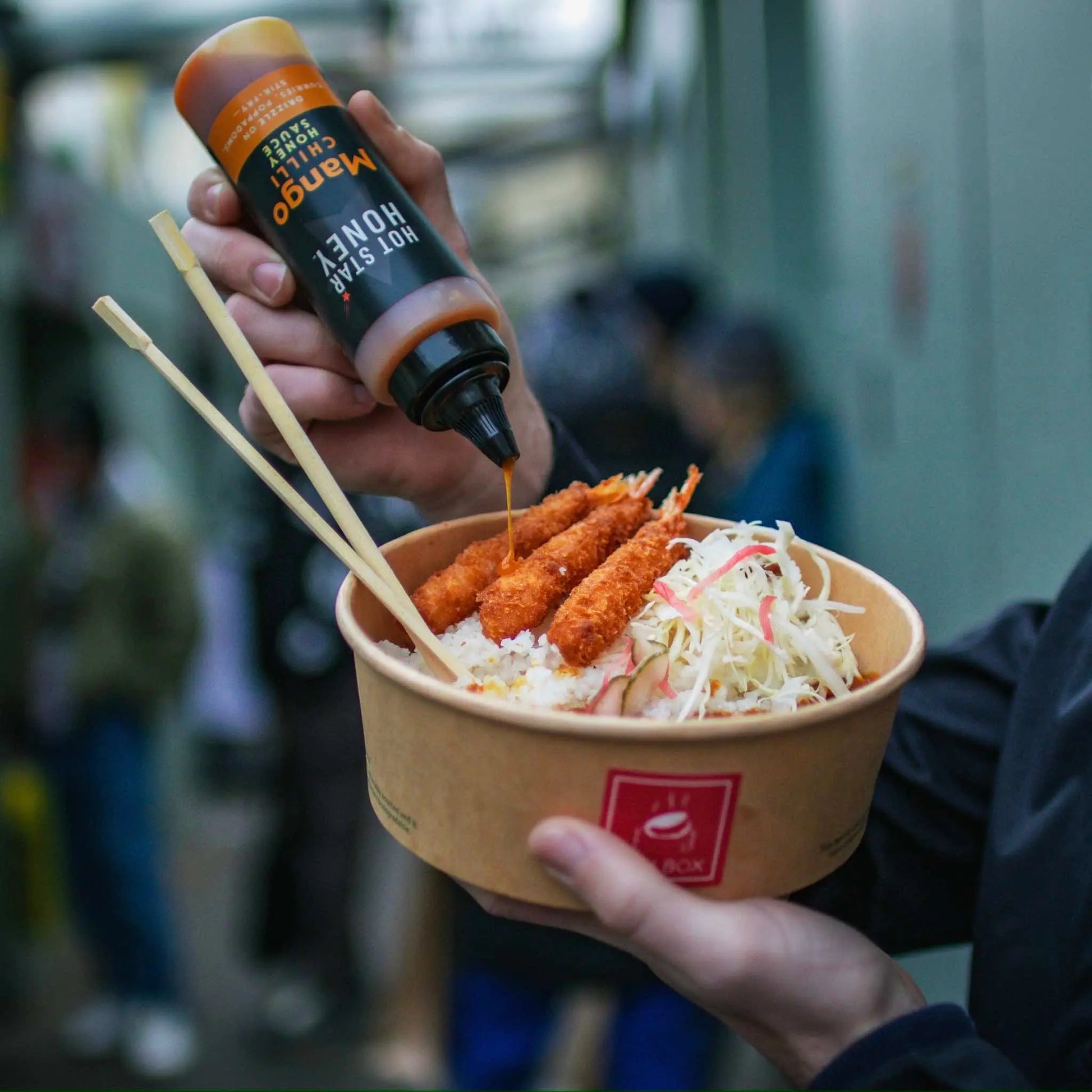 Asian-inspired Mango Chilli Honey Sauce by Hot Star Honey, featuring fresh mango pieces and a spicy sweet glaze on a dish.