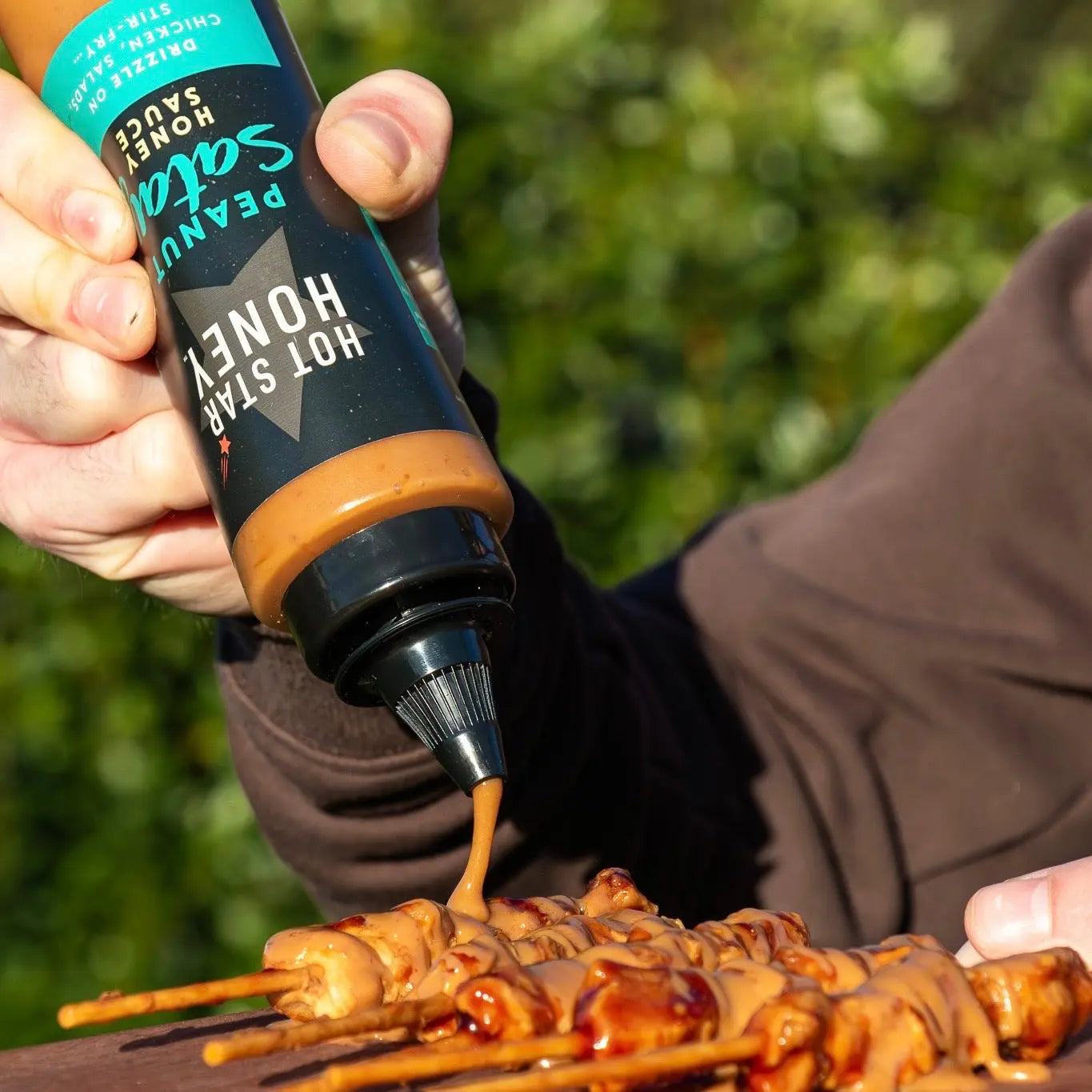Asian-inspired Hot Star Honey Peanut Satay Sauce drizzled over grilled chicken, showcasing a creamy, flavorful peanut satay sauce.