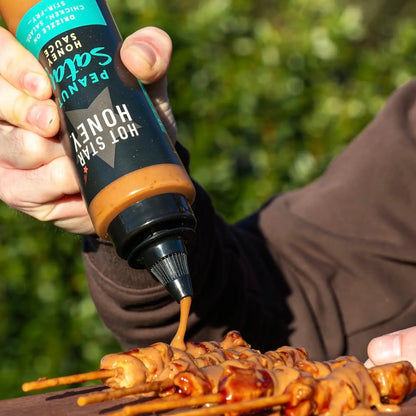 Asian-inspired Hot Star Honey Peanut Satay Sauce drizzled over grilled chicken, showcasing a creamy, flavorful peanut satay sauce.