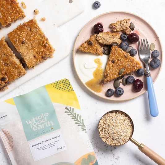 Whole Food Earth Pinhead Oatmeal Coarse Stabilized cereal in a bowl with fresh fruit and milk, showcasing a healthy breakfast option.
