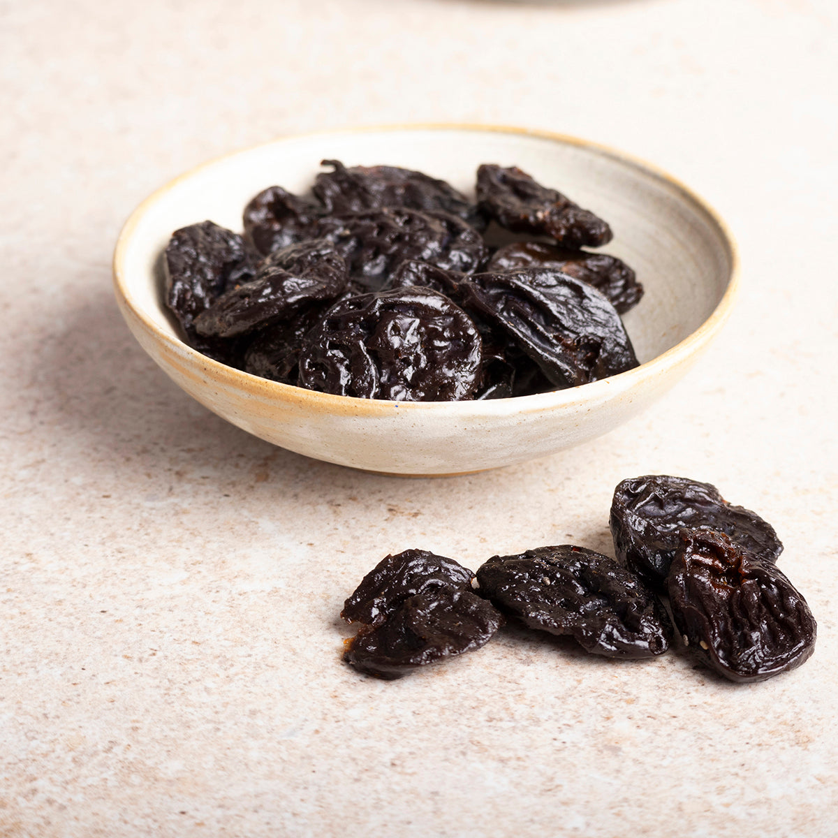 Medium-sized pitted prunes from Whole Food Earth, dried fruit with smooth, dark, and glossy surface, ready for snacking or baking.