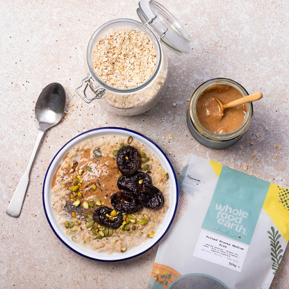 Pitted medium-sized prunes from Whole Food Earth, dried fruit, shown in a lifestyle setting with a bowl of prunes.
