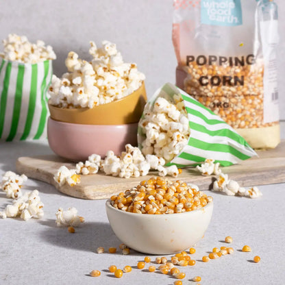 Whole Food Earth popping corn in a bowl, showcasing fresh, fluffy popcorn on a rustic wooden table.