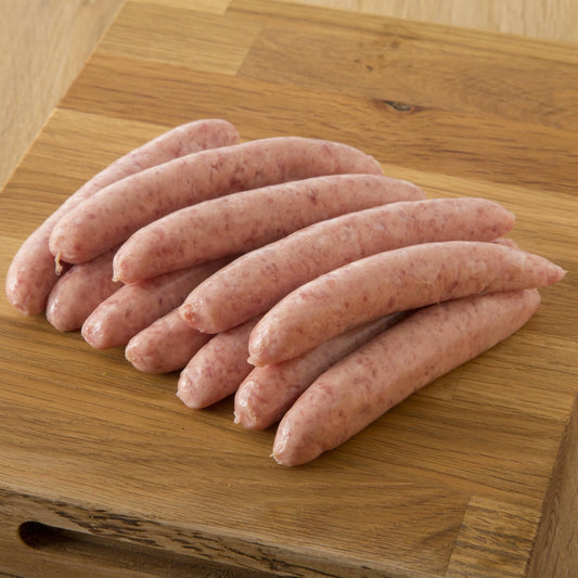Primrose Herd chipolata sausage variety pack with assorted pork chipolatas on a white plate, ready for cooking or serving.