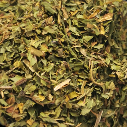 A cup of Porter Hill Tea Company's peppermint fruit and herbal tea with fresh peppermint leaves on a rustic wooden table.