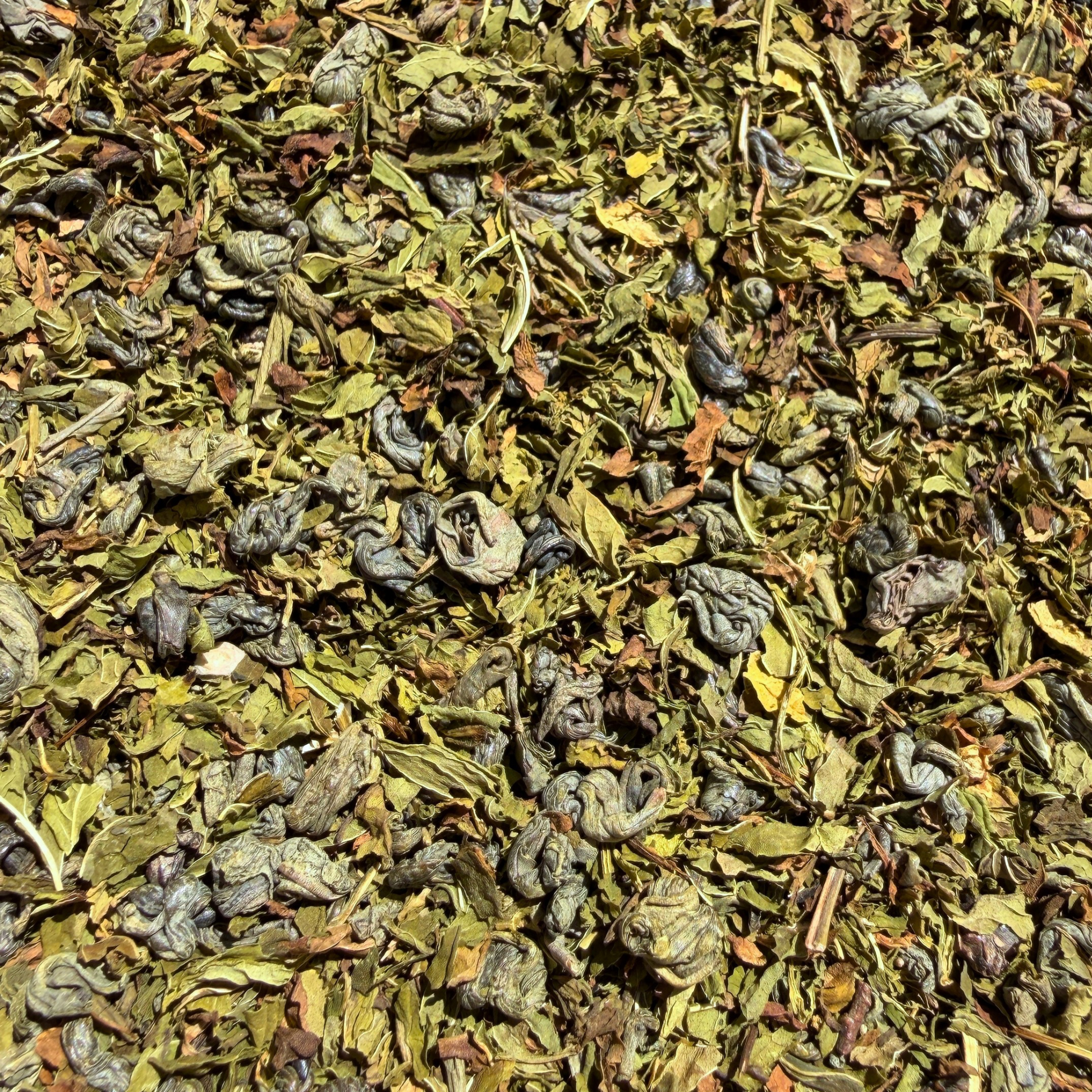 Loose leaf Mint Bazaar green tea by Porter Hill Tea Company with fresh mint leaves and vibrant green tea leaves in a clear container