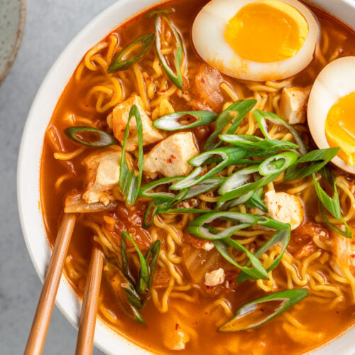 Spicy kimchi with tofu on ramen noodles, served in a bowl, from Cultura Live Food, showcasing fresh ingredients and vibrant colors.