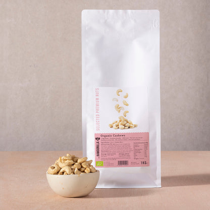 Raw organic cashew nuts from RAWGORILLA in a 1kg pack, displayed in a bowl with some nuts spilled around.