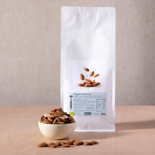Raw organic almonds from RAWGORILLA in a 1kg pack, displayed in a clear bowl with whole, natural almonds on a wooden surface.
