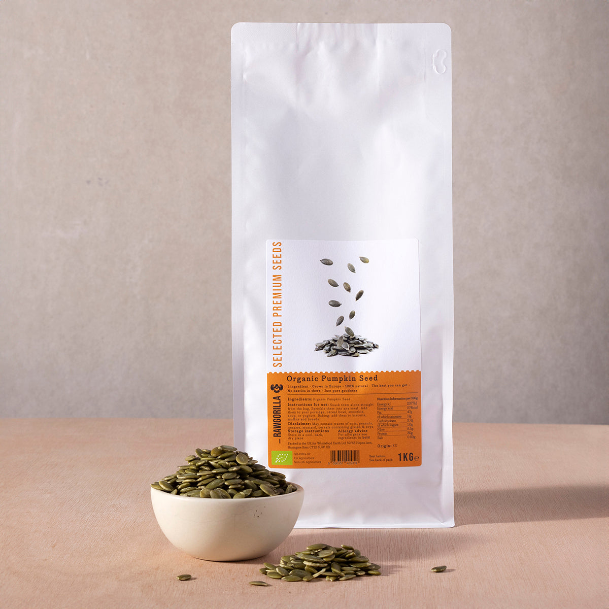 Raw organic pumpkin seeds from RAWGORILLA, 1kg package, showing light green seeds in a clear container, from Whole Food Earth.