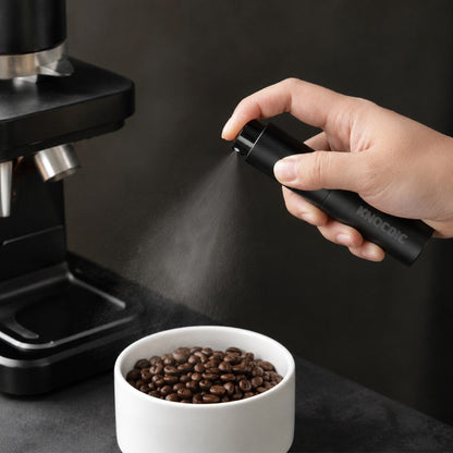 KNOCDIC® anti-static coffee bean spray bottle being used to reduce static in coffee beans during preparation.