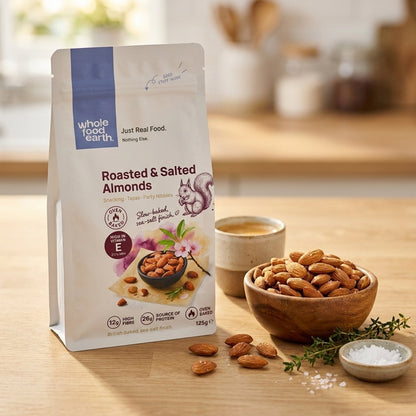 Baked roasted and salted almonds by Whole Food Earth, showing a handful of crunchy nuts in a natural setting.