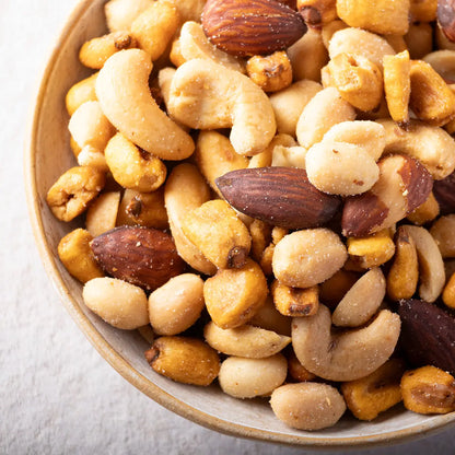 A bowl of salted mixed nuts including almonds, cashews, and peanuts, from Whole Food Earth, showcasing a variety of nuts and seeds.