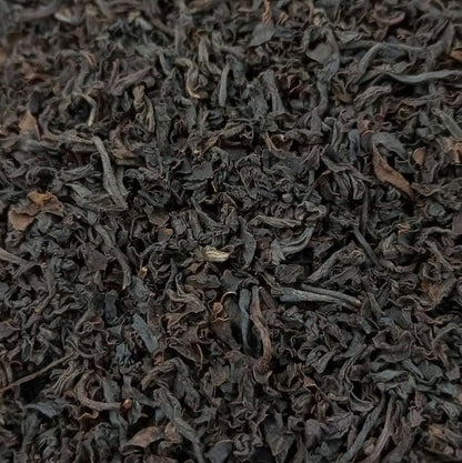 Black Santosa BOPS tea leaves from Porter Hill Tea Company, showcasing loose tea in a clear container with a dark, rich appearance.