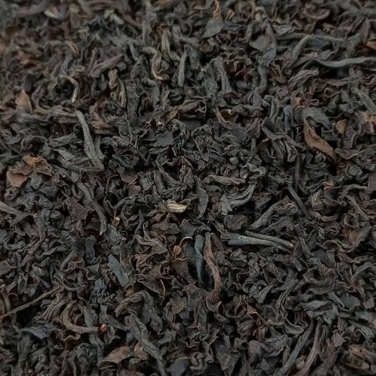 Black Santosa BOPS tea leaves from Porter Hill Tea Company, showcasing loose tea in a clear container with a dark, rich appearance.