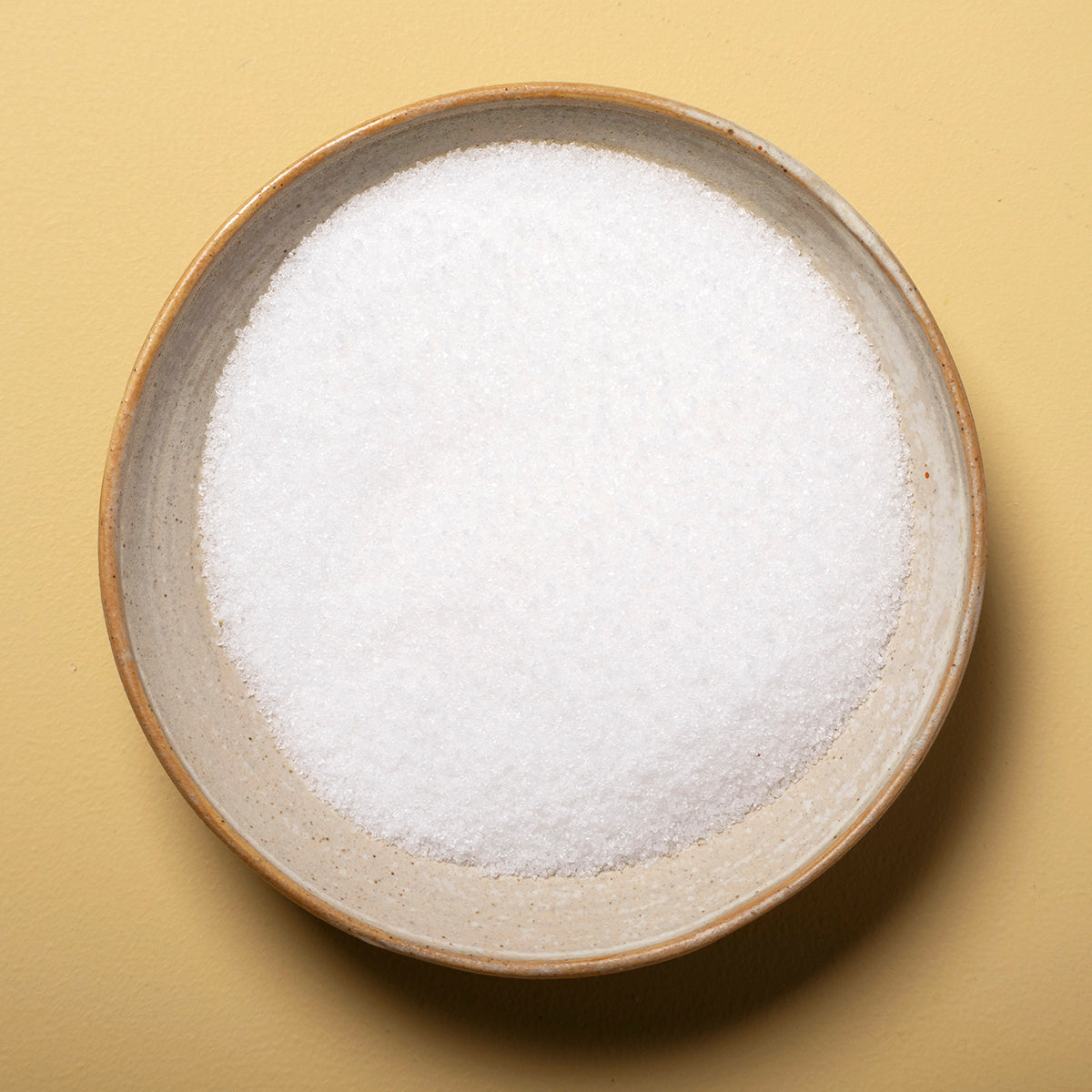 Close-up of fine sea salt from Whole Food Earth, showing white crystalline mineral salt grains on a white background.
