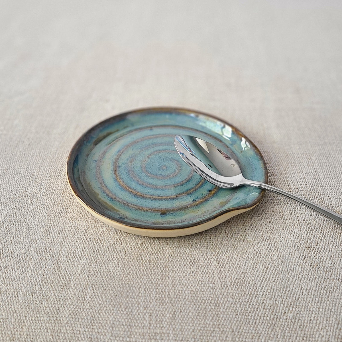 Seafoam blue ceramic spoon rest by Katie L Thompson Designs, with a classic, smooth design ideal for kitchen use.