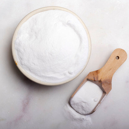 Sodium bicarbonate baking soda in a clear container, showing the fine white mineral powder from Whole Food Earth.