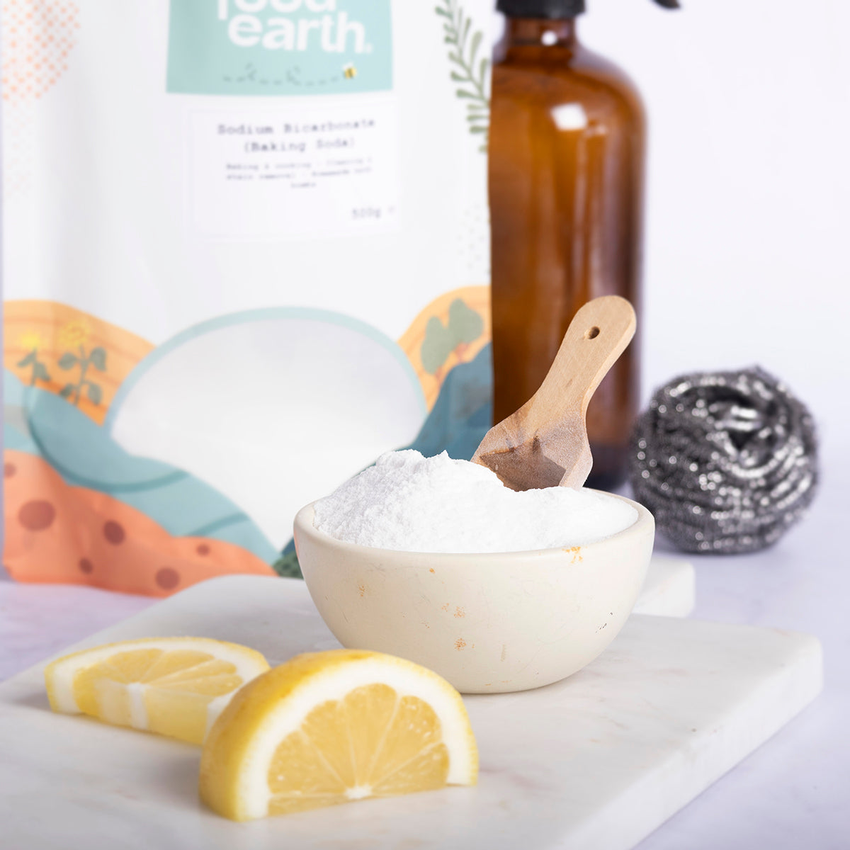 Sodium bicarbonate baking soda in a white container, with a spoon and baking ingredients on a kitchen countertop.
