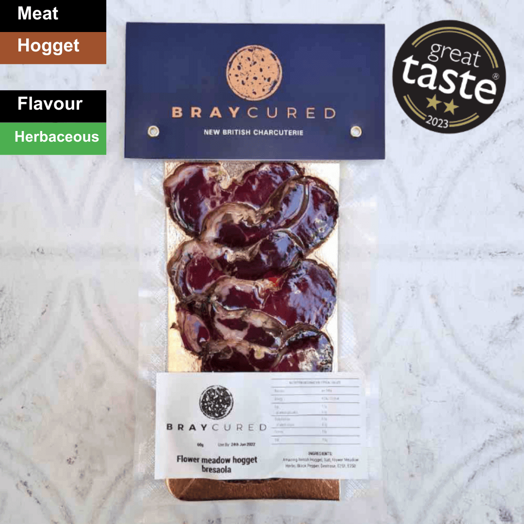 Thin slices of Bray Cured Hogget Bresaola charcuterie with a spicy flavor profile on a wooden serving board.