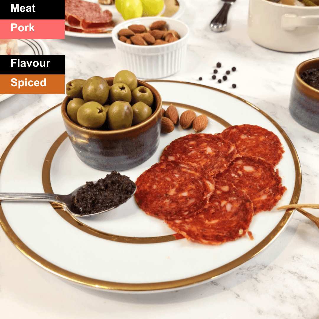 Spicy British chorizo slices from Bray Cured, showcasing vibrant red color and seasoned texture on a charcuterie board.