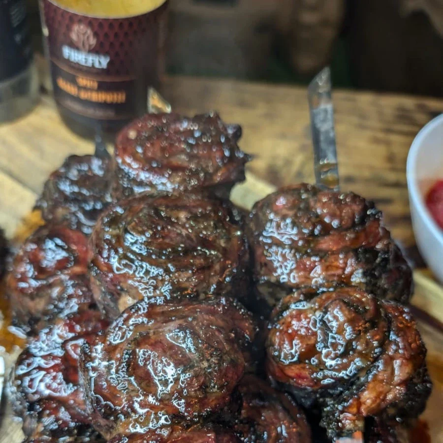 Spicy beef pin wheels served with FireFly Barbecue hot agave nectar BBQ sauce on a plate.