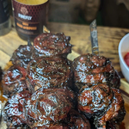 Spicy beef pin wheels served with FireFly Barbecue hot agave nectar BBQ sauce on a plate.