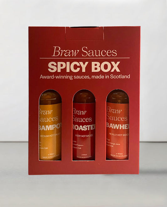 Braw Sauces Spicy Box Gift Set with various hot sauce bottles displayed on a wooden surface.