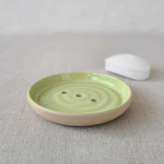 Spring green ceramic soap dish from Katie L Thompson Designs with a bar of soap on top.