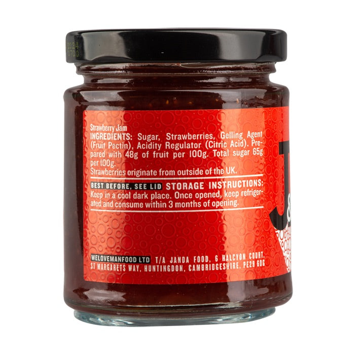 Jar of Janda strawberry jam with fresh strawberries and spreadable texture, showcasing a fruity, homemade look.