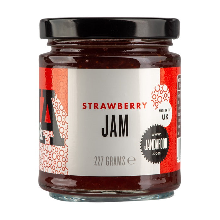 Jar of Janda strawberry jam with fresh strawberries and spread on bread, showcasing a fruity, homemade-style spread.