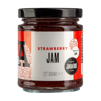 Jar of Janda strawberry jam with fresh strawberries and spread on bread, showcasing a fruity, homemade-style spread.