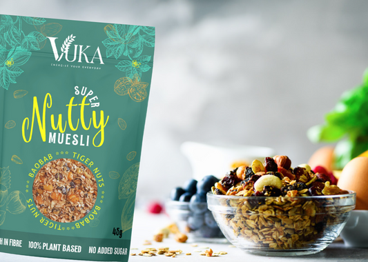 Goch & Co Super Nutty Muesli with baobab and tiger nuts in a bowl with scoop and scattered ingredients on a wooden surface
