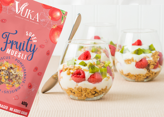 A bowl of Super Fruity Muesli with hibiscus and pomegranate, served with yogurt for a healthy breakfast.